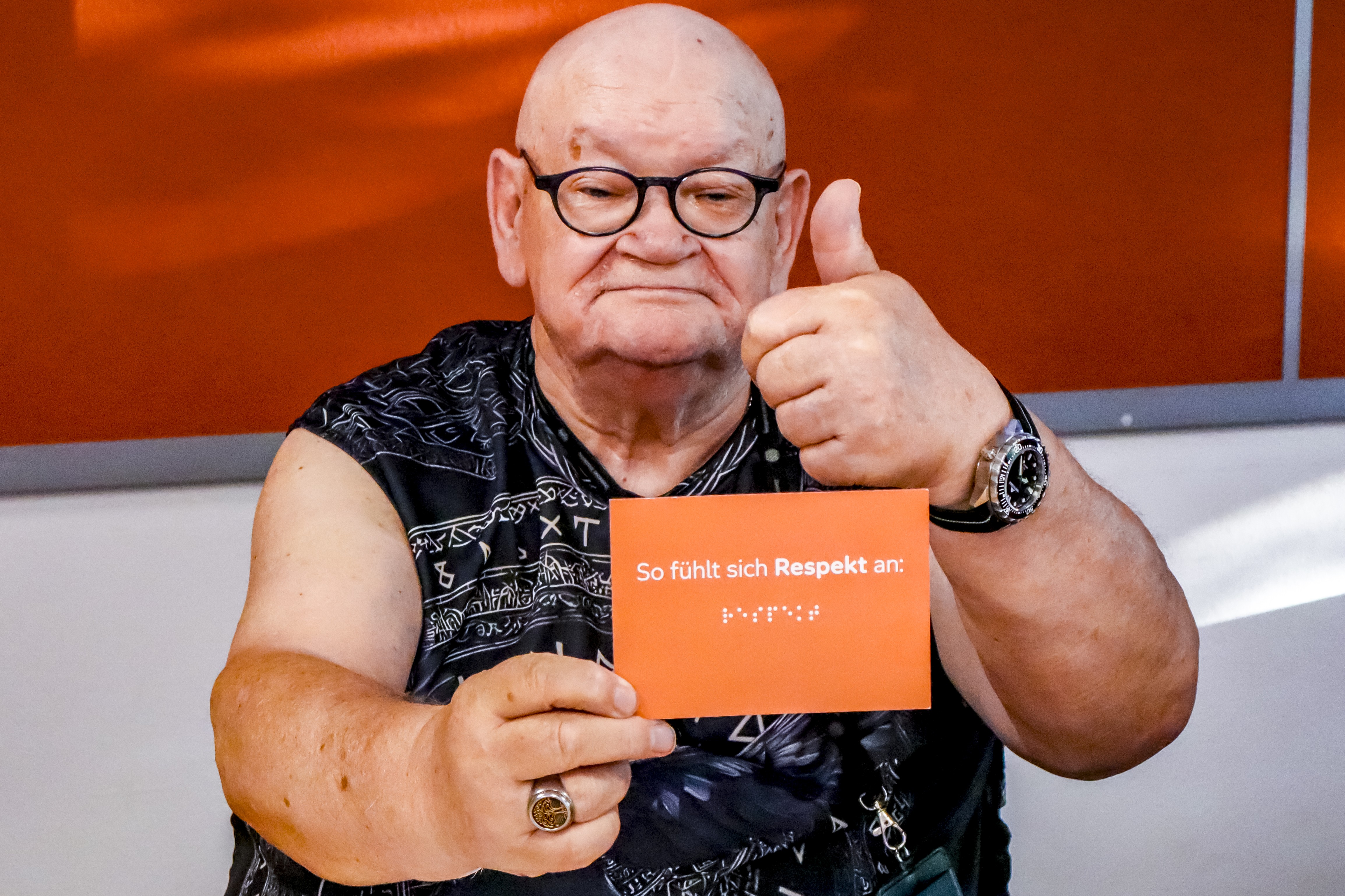 Klaus Günter Mattlat hält eine Karte hoch, auf der steht: So fühlt sich Respekt an. 