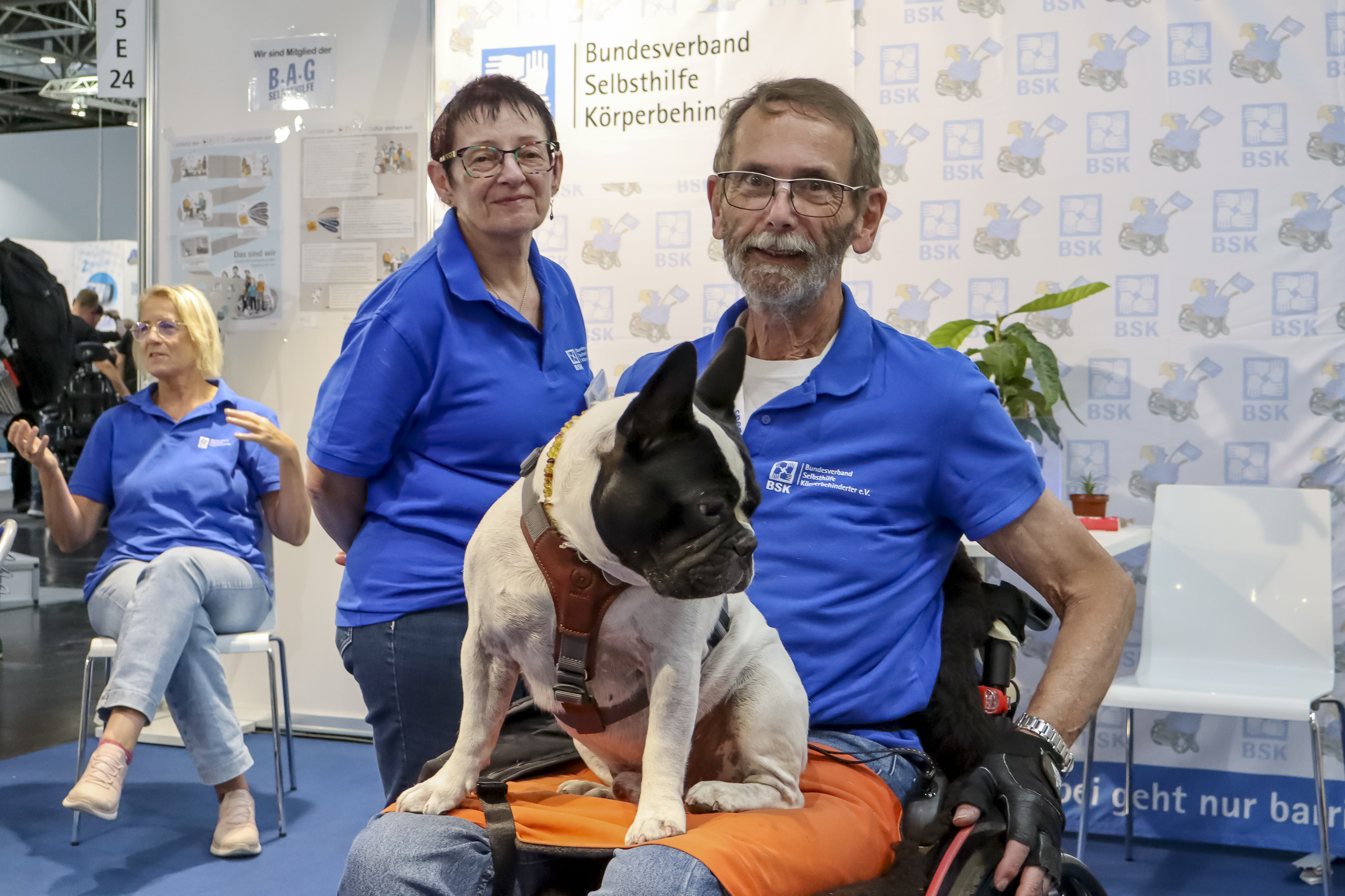 Ehrenamtlicher im Rollstuhl mit Hund auf dem Schoß