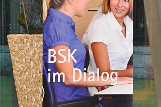 Roll up mit Foto von zwei Personen die sich unterhalten. Darunter steht BSK im DIALOG