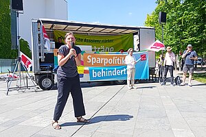 Sprecherin vor dem Kanzleramt, dahinter ein Wagen und Jörg Bechtold