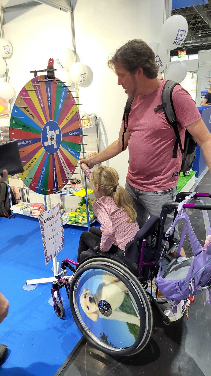 Kind im Rollstuhl dreht am Glücksrad