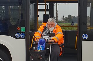 Foto zeigt E-Scooter-FAhrer der einen ÖPNV Bus über eine Rampe verläßt