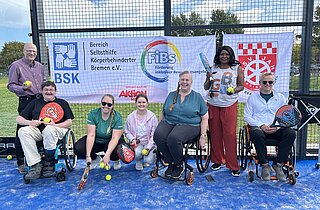 Gruppenfoto mit Banner auf dem Sportplatz