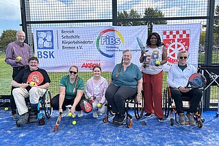 Gruppenfoto mit Banner auf dem Sportplatz