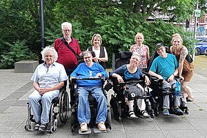 Gruppenfoto - vier Mitglieder im Rollstuhl, dahinter vier Läufer