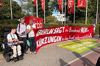 Jörg Bechtold und andere halten ein Banner hoch