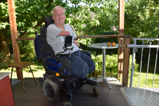 Matthias Krasa in seinem Rollstuhl auf einer Terasse.