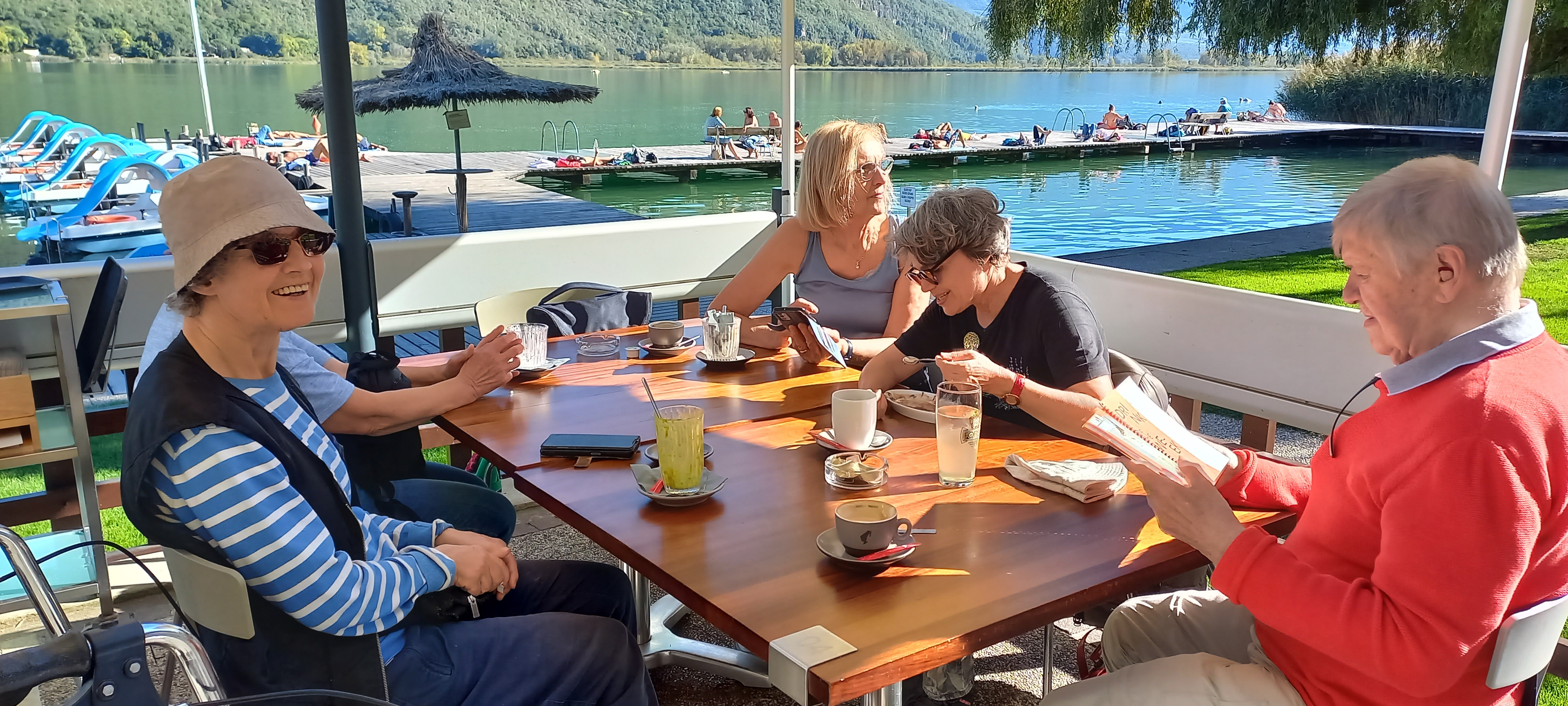 Vier Menschen am See beim Kaffeetrinken