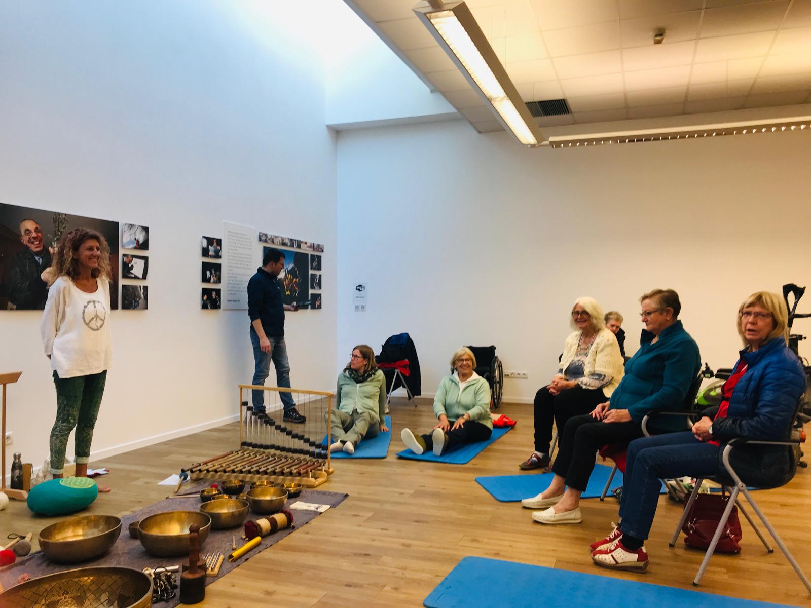 Menschen auf dem Boden oder auf einem Stuhl in einem Meditationsraum